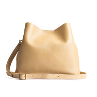  Champagne | symmetrical bucket bag with latch closure and removable crossbody strap