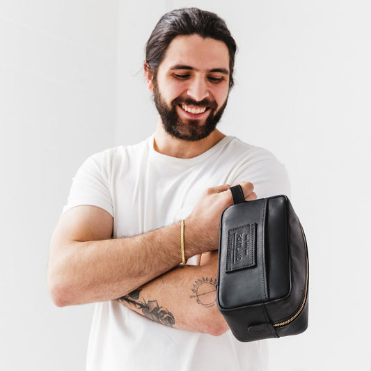 All Color: Black | Model holding large rectangular leather dopp kit