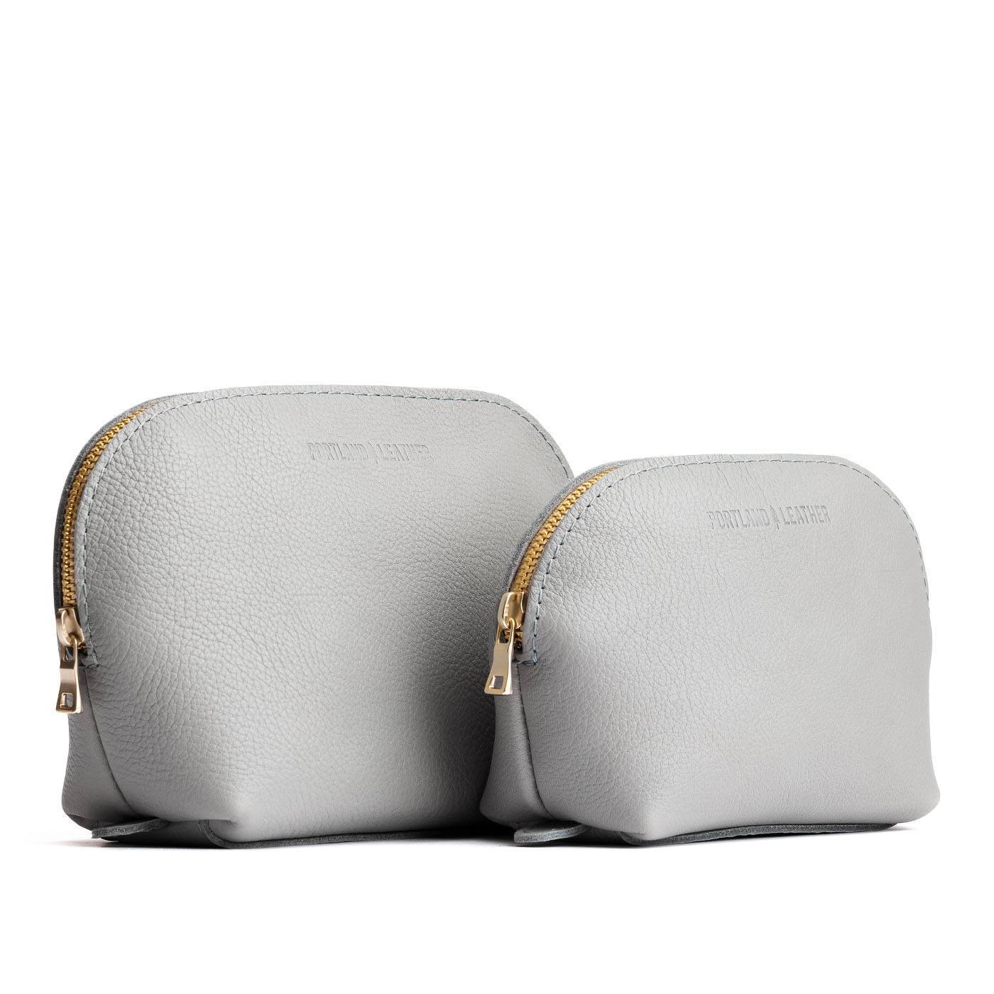 Nimbus | Size comparison shot of leather makeup bags with curved top zipper and flat bottom