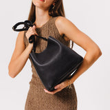 Pebbled--black | symmetrical bucket bag with latch closure and removable crossbody strap