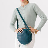 Lagoon Large | Model holding circle shaped crossbody bag with top zipper