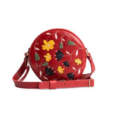Folklore Ruby Small | Circle shaped crossbody bag with embroidered flower design