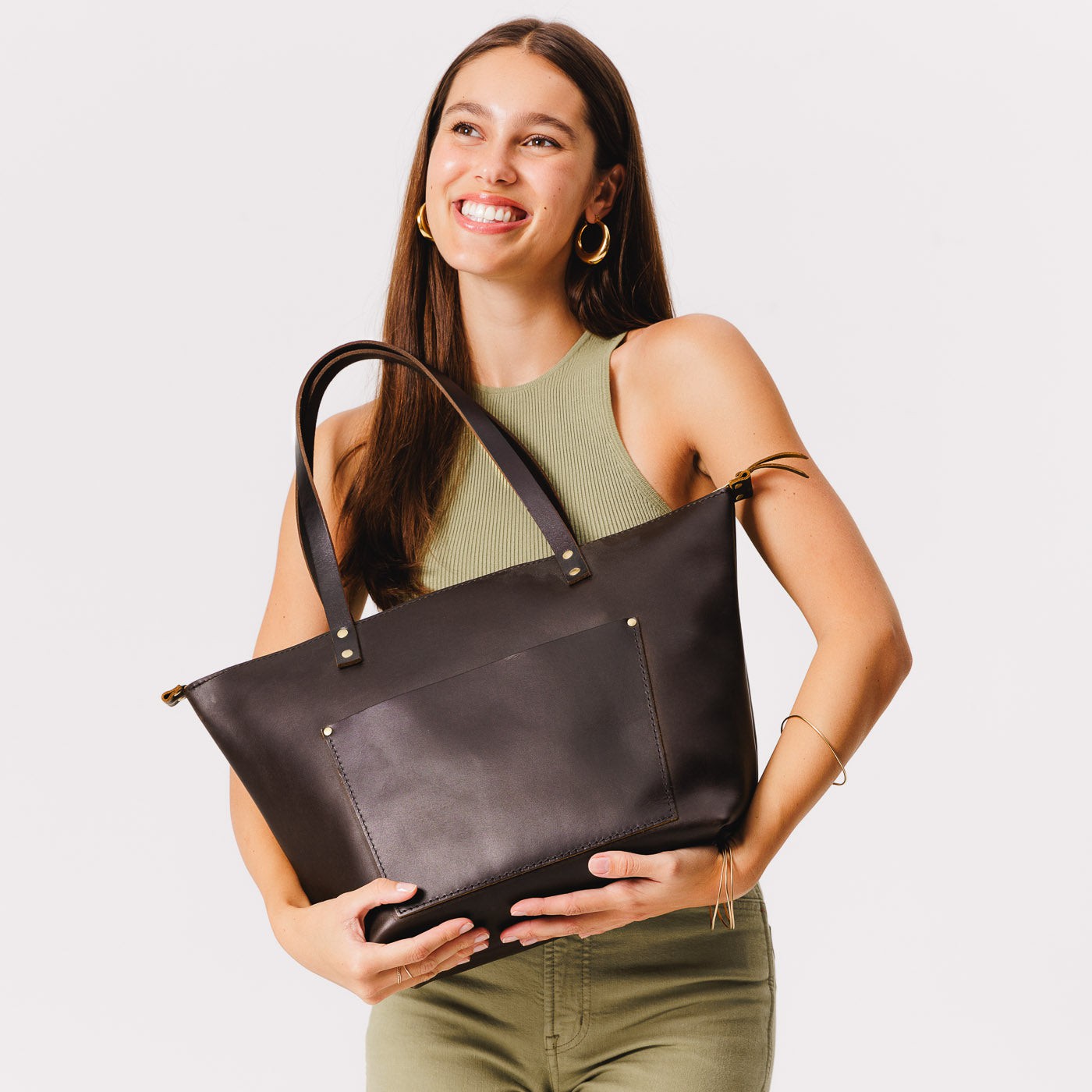 Grizzly*Zipper | Model holding large zipper leather tote bag with sturdy bridle handles and front pocket