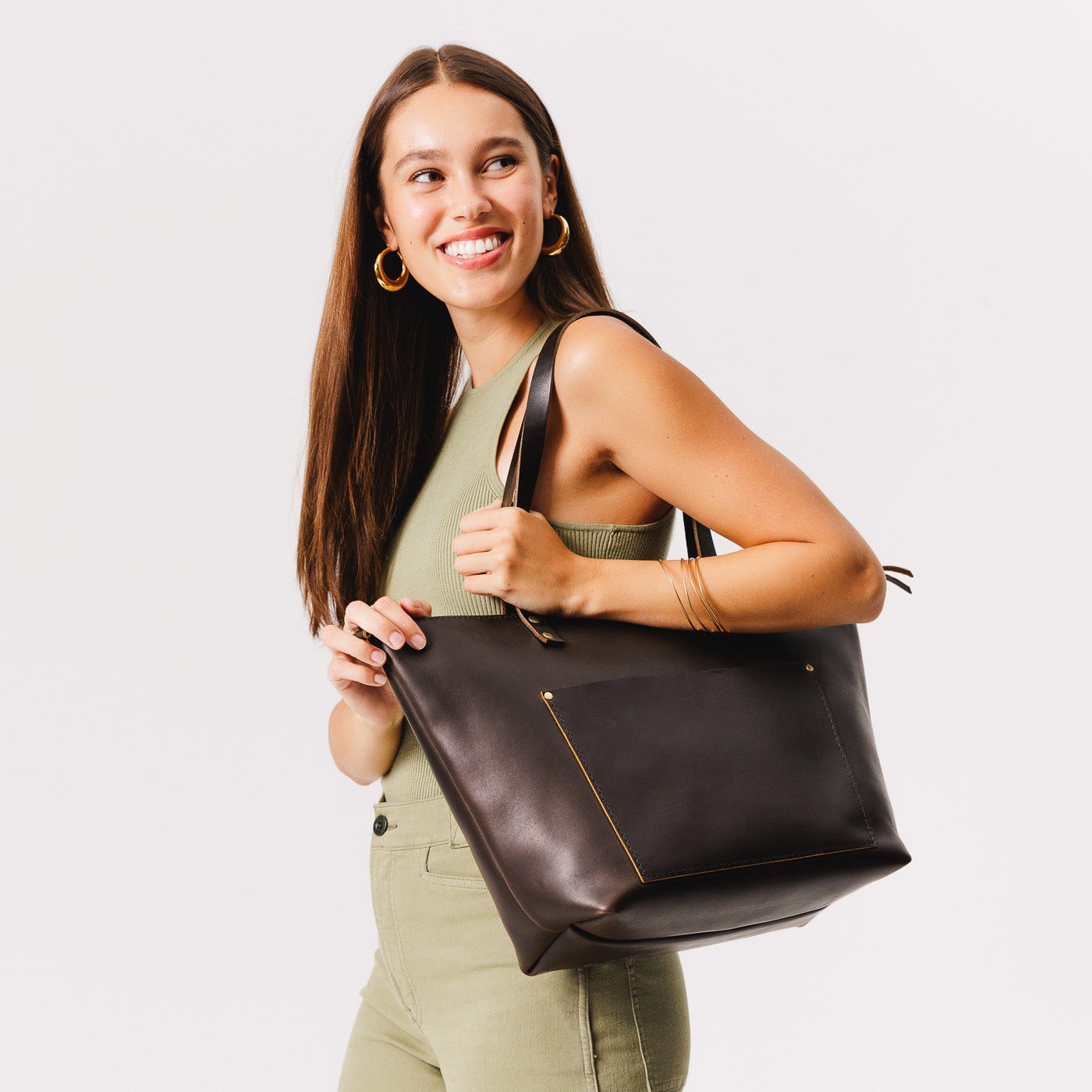 Grizzly*Zipper | Model holding large zipper leather tote bag with sturdy bridle handles and front pocket