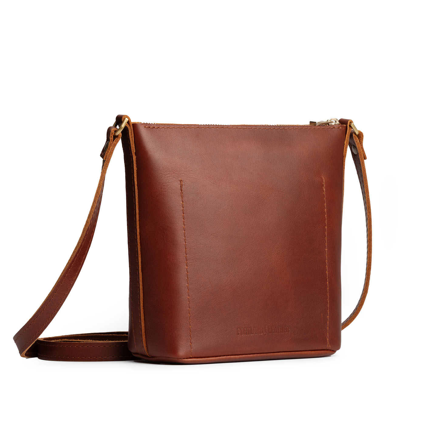 Chestnut | Back of rectangular side bag with curved front pocket and metal tree shaped badge