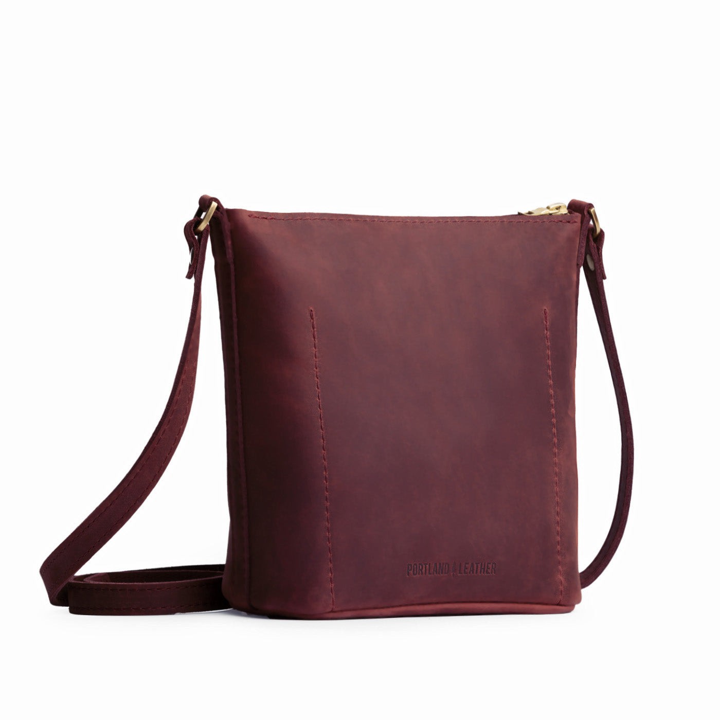 Merlot | Back of rectangular side bag with curved front pocket and metal tree shaped badge