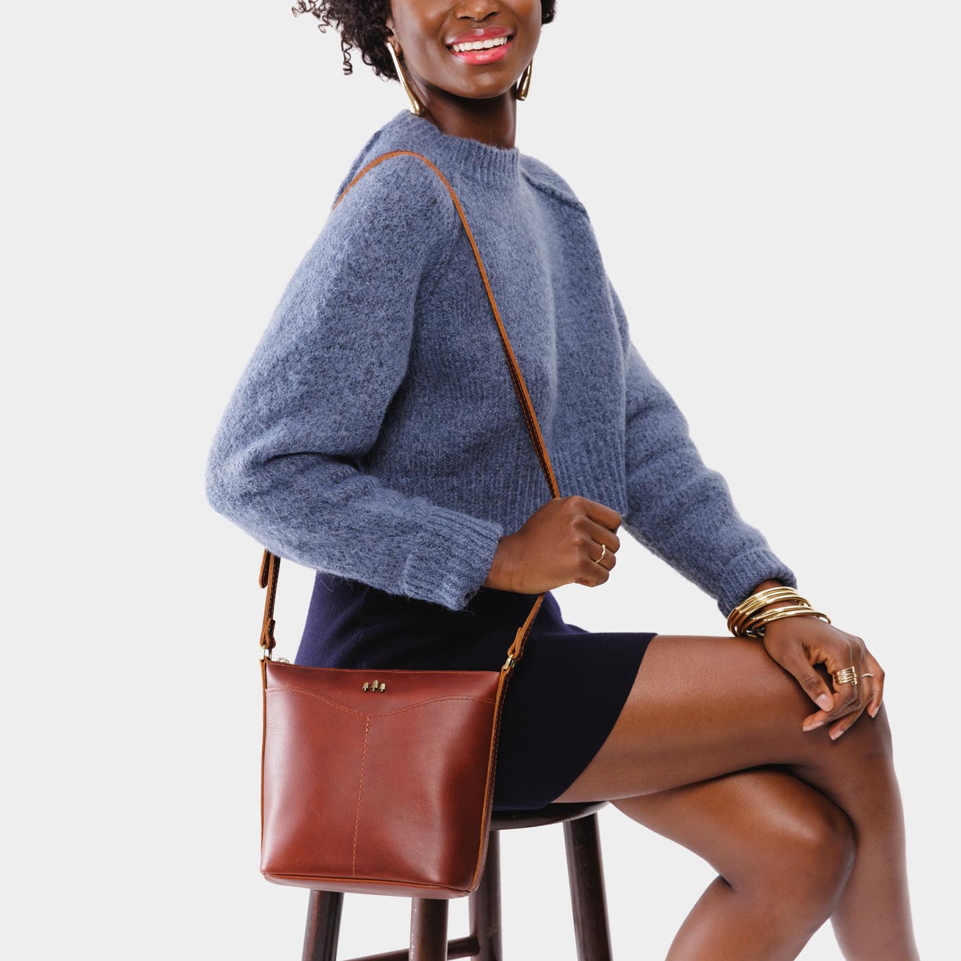 Chestnut | Model wearing rectangular side bag with curved front pocket and metal tree shaped badge