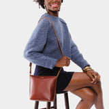 Chestnut | Model wearing rectangular side bag with curved front pocket and metal tree shaped badge