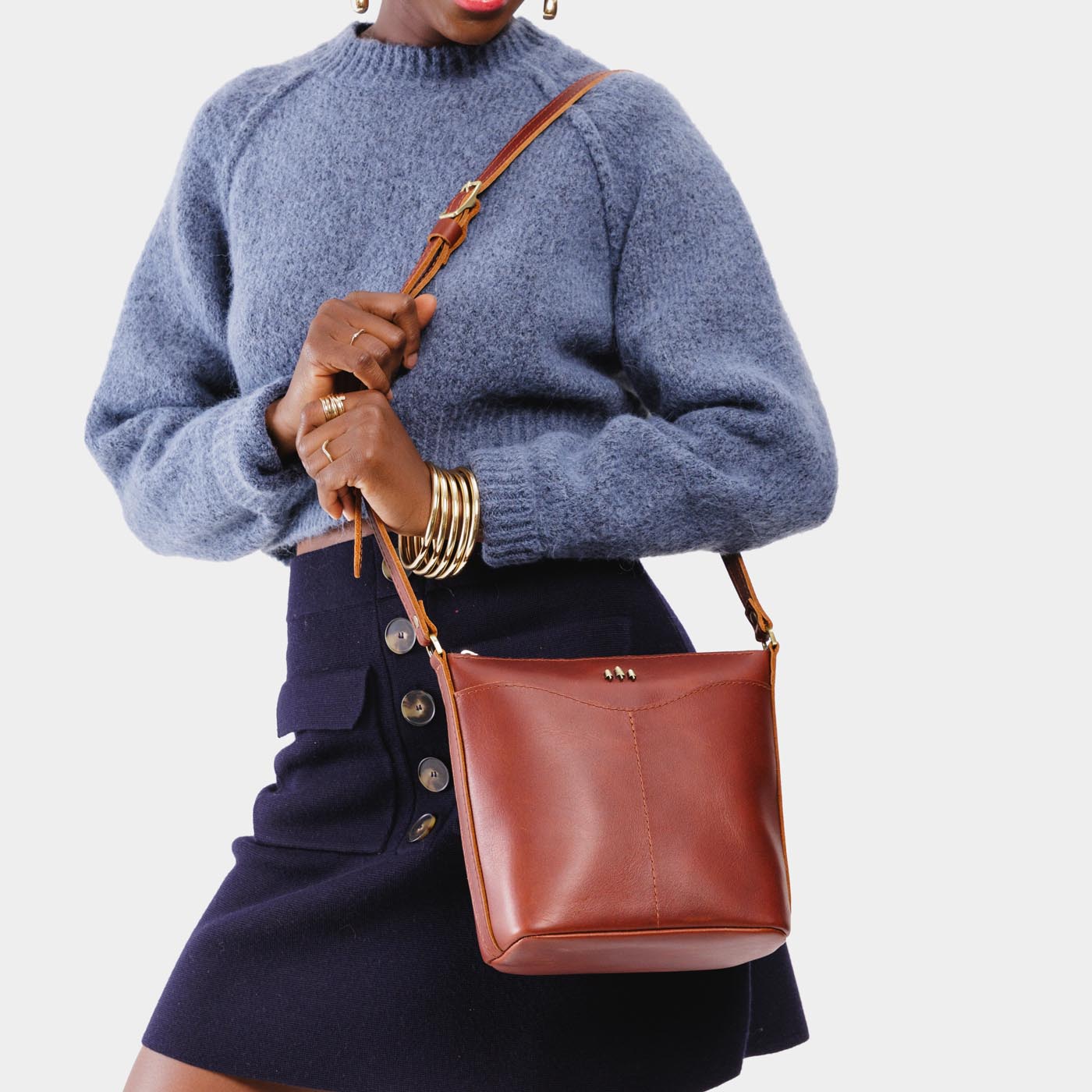 Chestnut | Model wearing rectangular side bag with curved front pocket and metal tree shaped badge