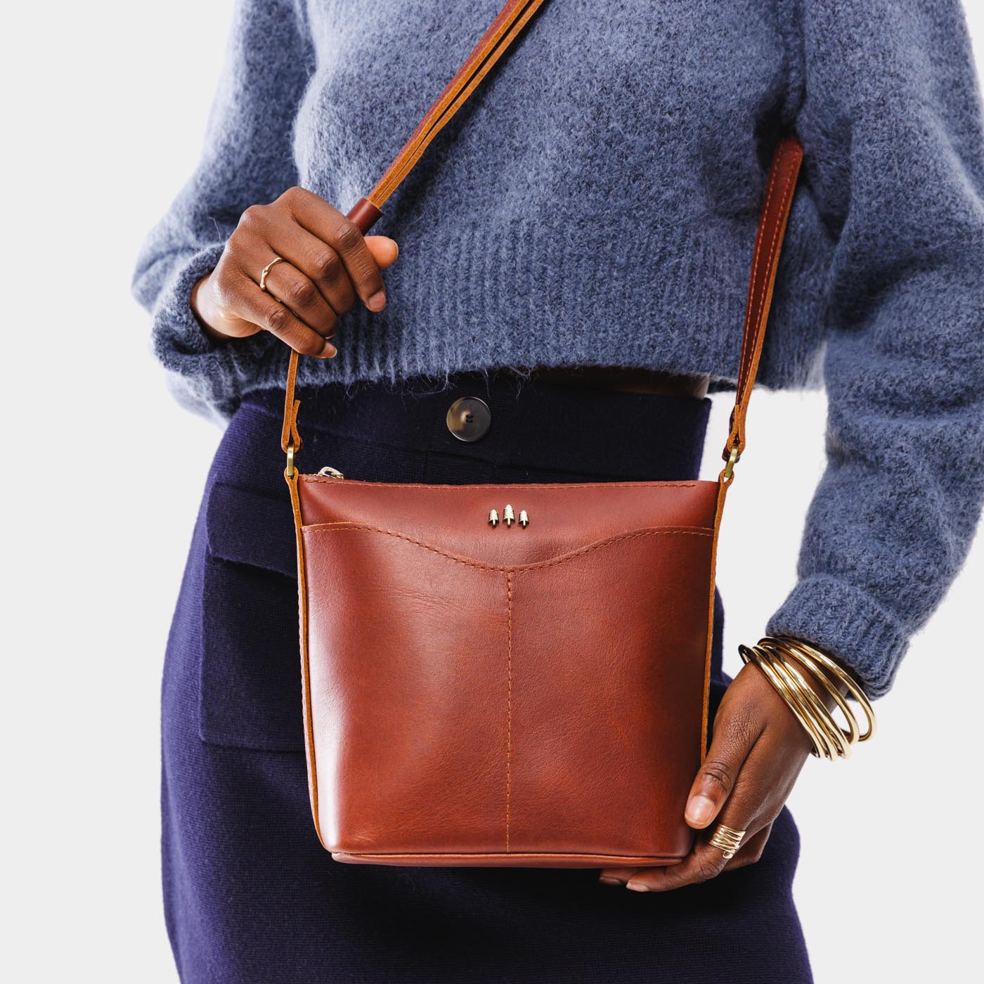 Chestnut | Model wearing rectangular side bag with curved front pocket and metal tree shaped badge