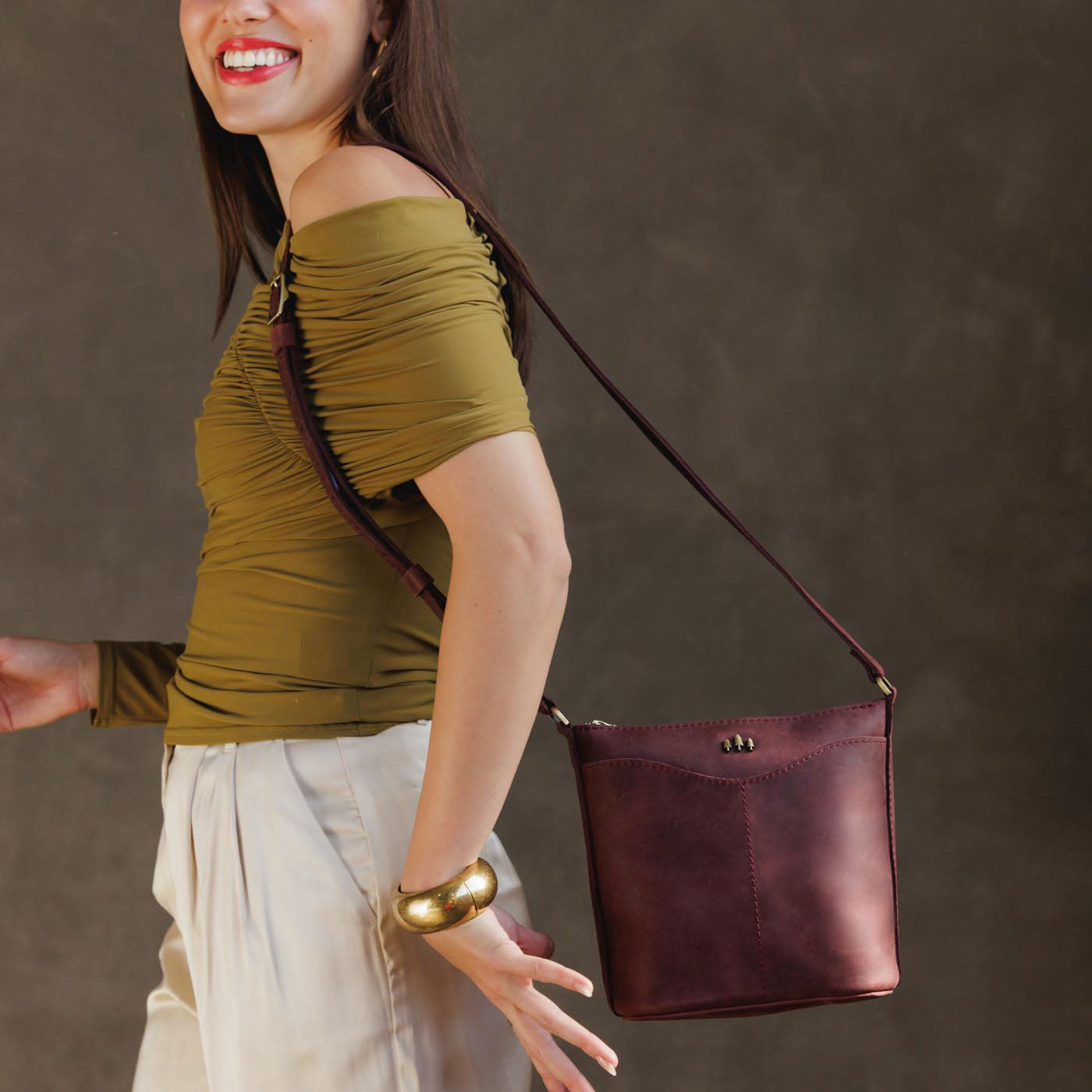 Merlot | Model wearing rectangular side bag with curved front pocket and metal tree shaped badge