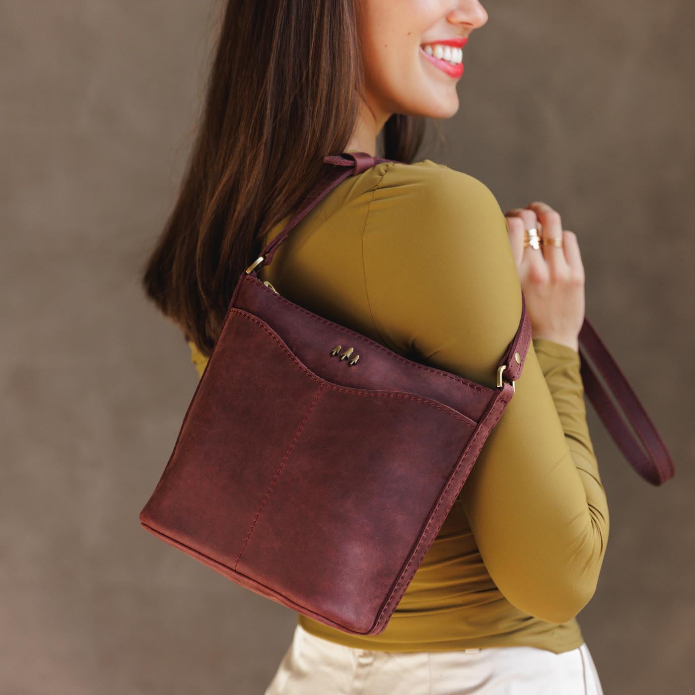 Merlot | Model wearing rectangular side bag with curved front pocket and metal tree shaped badge