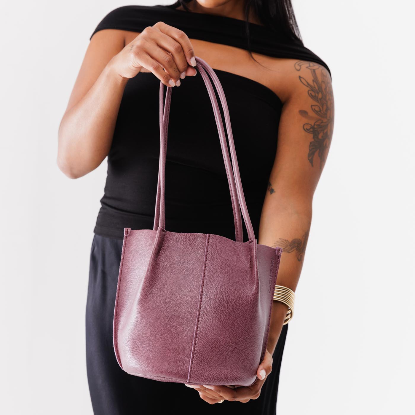 Kyoto | Model holding petite bucket shaped tote bag with matching leather handles