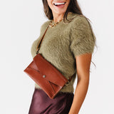 Chestnut | Model wearing envelope shaped clutch wallet with crossbody strap