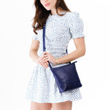 Cobalt | Model wearing small rectangular crossbody purse with top zipper and interior pocket