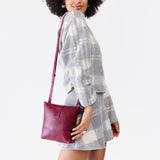 Orchid | Model wearing small rectangular crossbody purse with top zipper and interior pocket