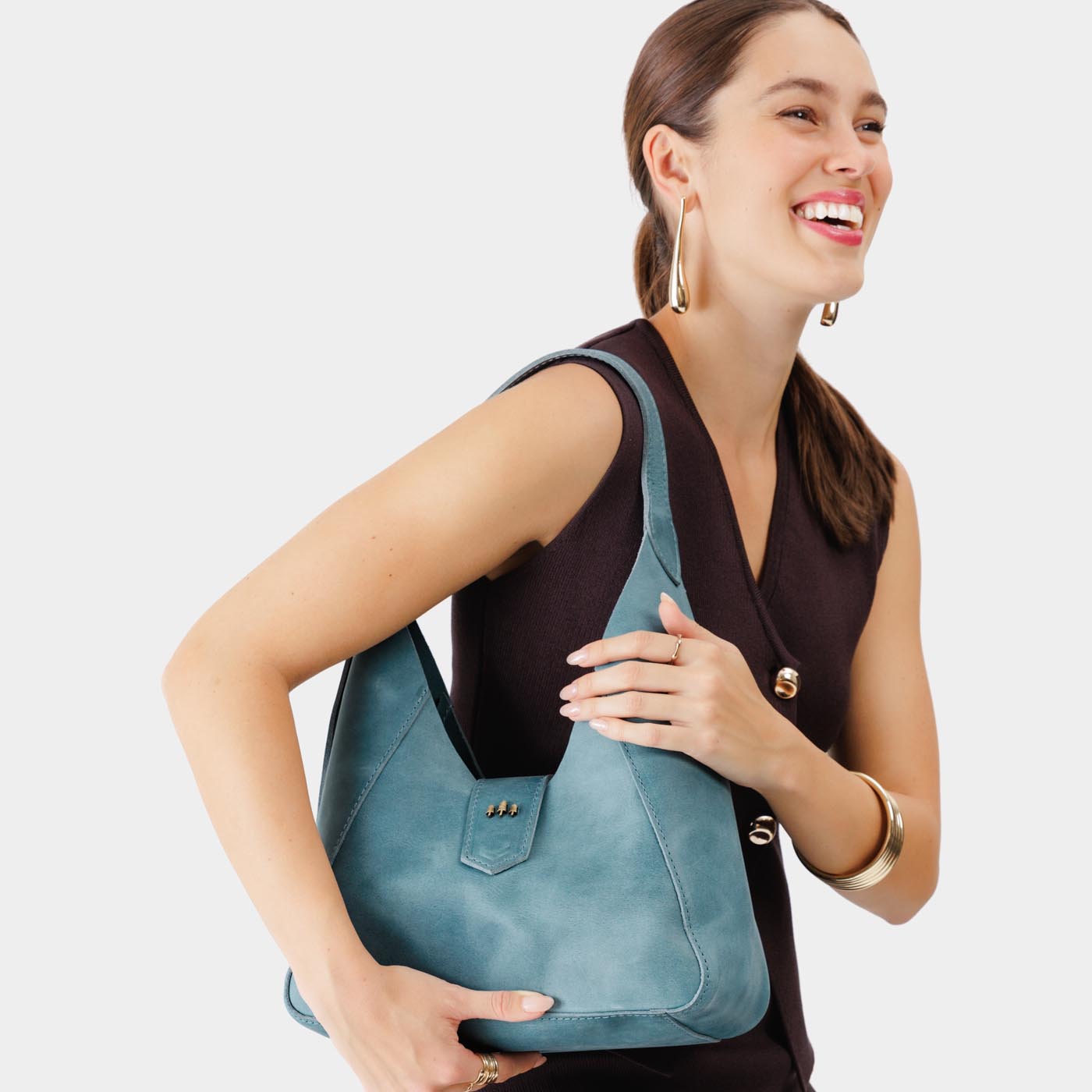 Aqua | Model wearing structured hobo shoulder bag with adjustable strap and magnetic closure