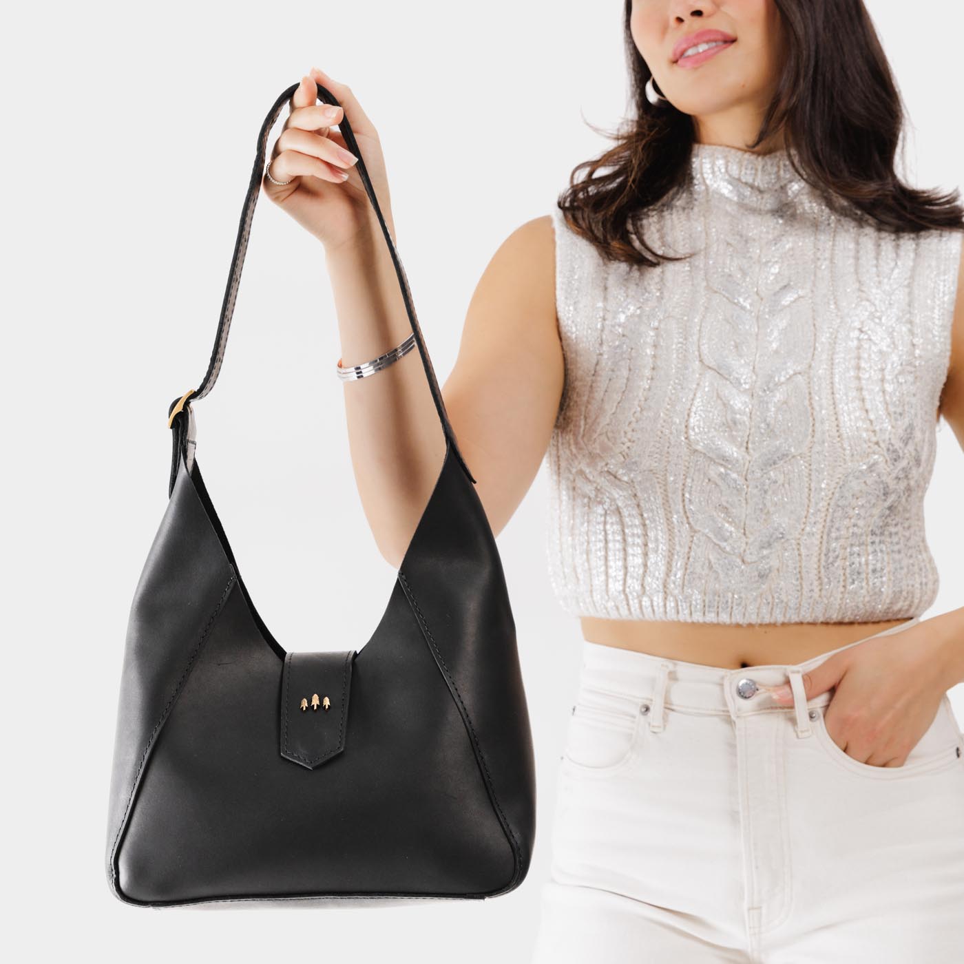 Black | Model holding structured hobo shoulder bag with adjustable strap and magnetic closure