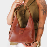 Chestnut | Model holding structured hobo shoulder bag with adjustable strap and magnetic closure