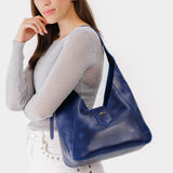 Cowboy Blue | Model wearing structured hobo shoulder bag with adjustable strap and magnetic closure