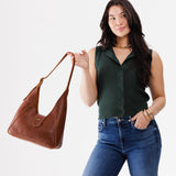 Nutmeg | Model holding structured hobo shoulder bag with adjustable strap and magnetic closure