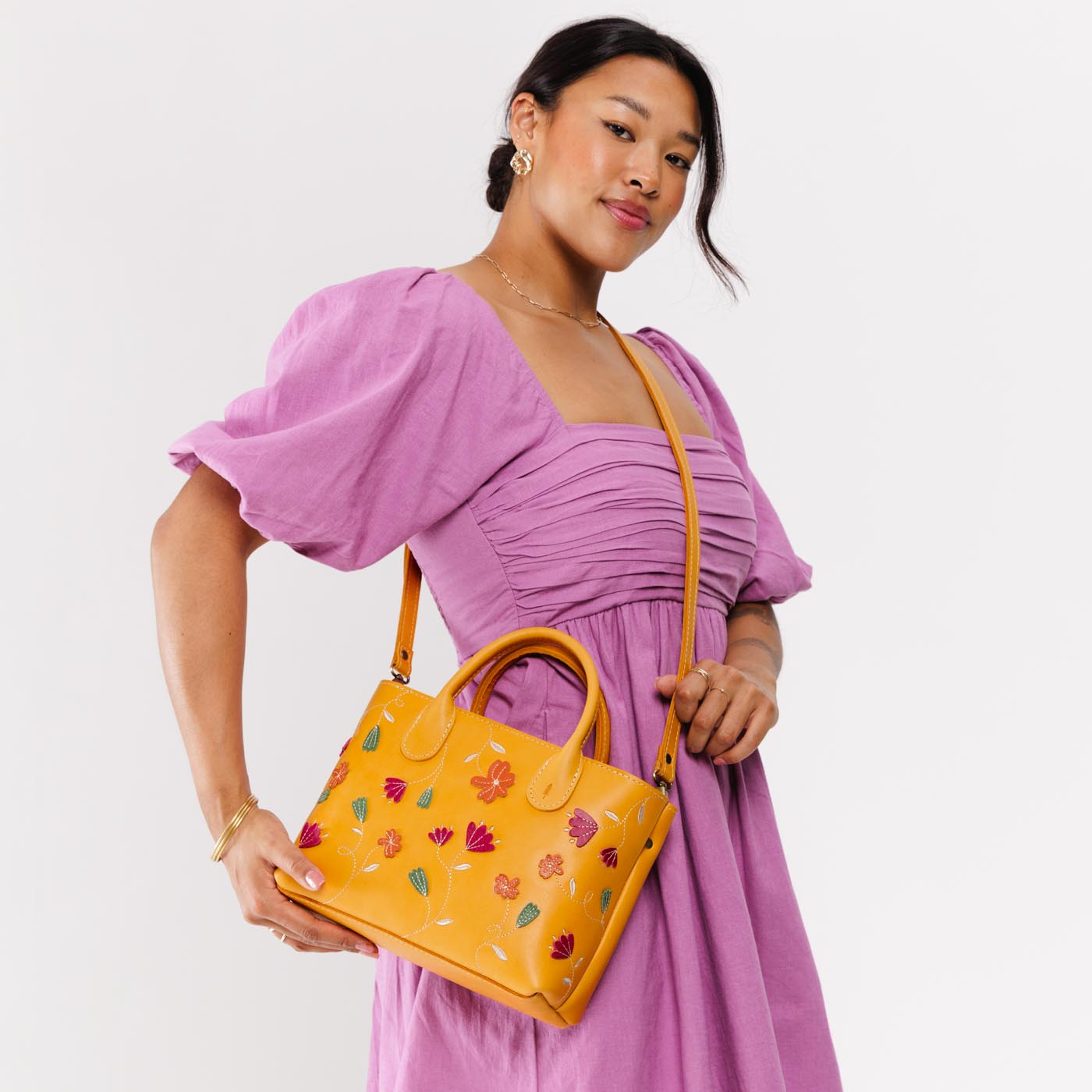 Folklore Sunflower*Large  | Model wearing mid-size tote purse with embroidered flower design, structured leather handles, and crossbody strap