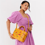 Folklore Sunflower Large  | Model wearing mid-size tote purse with embroidered flower design, structured leather handles, and crossbody strap