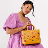 Folklore Sunflower Large  | Model wearing mid-size tote purse with embroidered flower design, structured leather handles, and crossbody strap