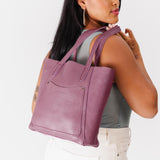 Kyoto Large | Model holding dual shoulder strap tote bag with an exterior pocket