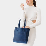 Deep Water Large | Model holding dual shoulder strap tote bag with an exterior pocket