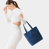 Deep Water Large | Model holding dual shoulder strap tote bag with an exterior pocket