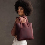 Merlot Large | Model holding dual shoulder strap tote bag with an exterior pocket