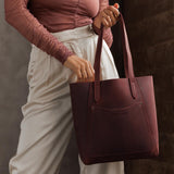 Merlot Large | Model holding dual shoulder strap tote bag with an exterior pocket