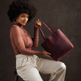 Merlot Large | Model holding dual shoulder strap tote bag with an exterior pocket