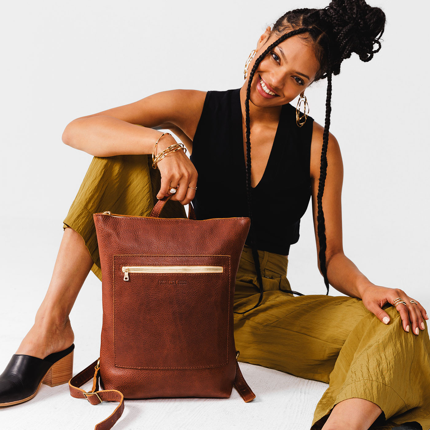 All Color: Nutmeg | Model holding rectangular slim leather backpack