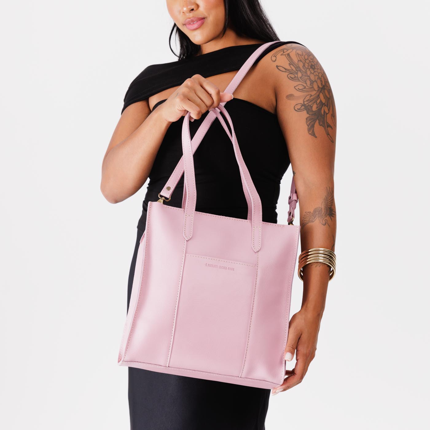 Vintage Pink*North/South  | Model holding structured large tote bag with overlapping panels and crossbody strap