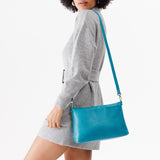 Baja | Model holding midsize zip top crossbody bag with detachable strap