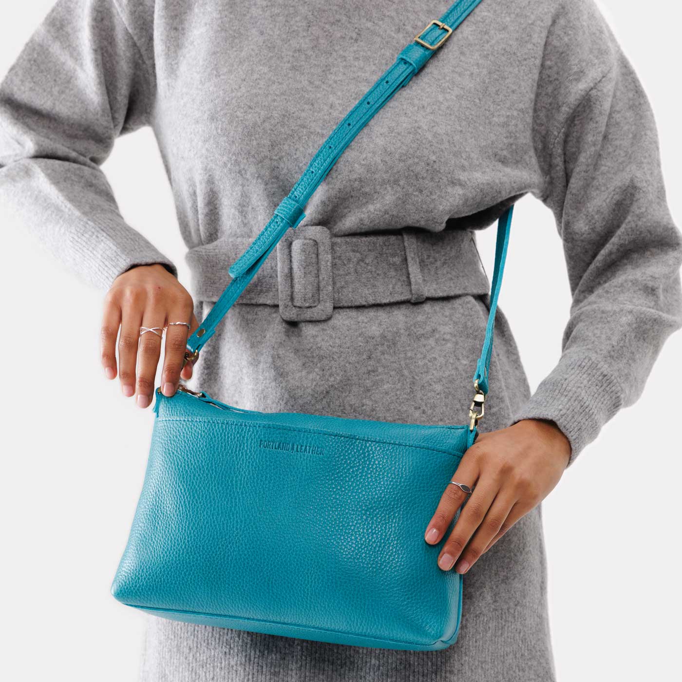 Baja | Model holding midsize zip top crossbody bag with detachable strap