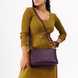 Plum | Model wearing midsize zip top crossbody bag with detachable strap