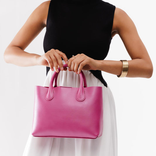 Lip Gloss*Large | Model holding mid-size tote purse with  structured leather handles and crossbody strap