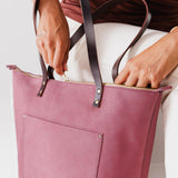 Foxglove Zipper | Model holding large leather tote bag with sturdy bridle handles and front pocket