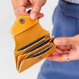 Sunflower Plus | Model holding small leather wallet with snap closure