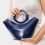 Cowboy Blue Small | Model holding structured leather hand bag with circular handles