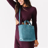 Aqua Classic | Model holding crossbody tote bag with zipper closure and front pocket