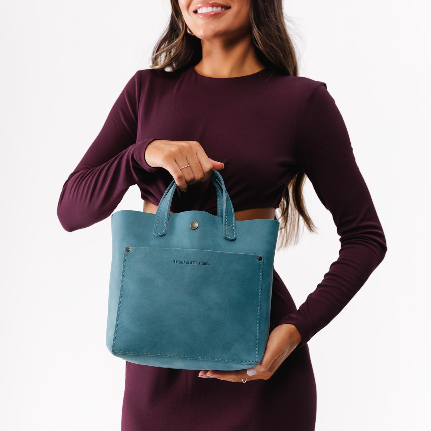 Aqua*Classic | Model holding crossbody tote bag with zipper closure and front pocket