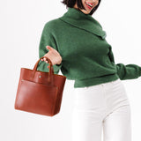 Chestnut Classic | Model holding crossbody tote bag with snap closure and front pocket