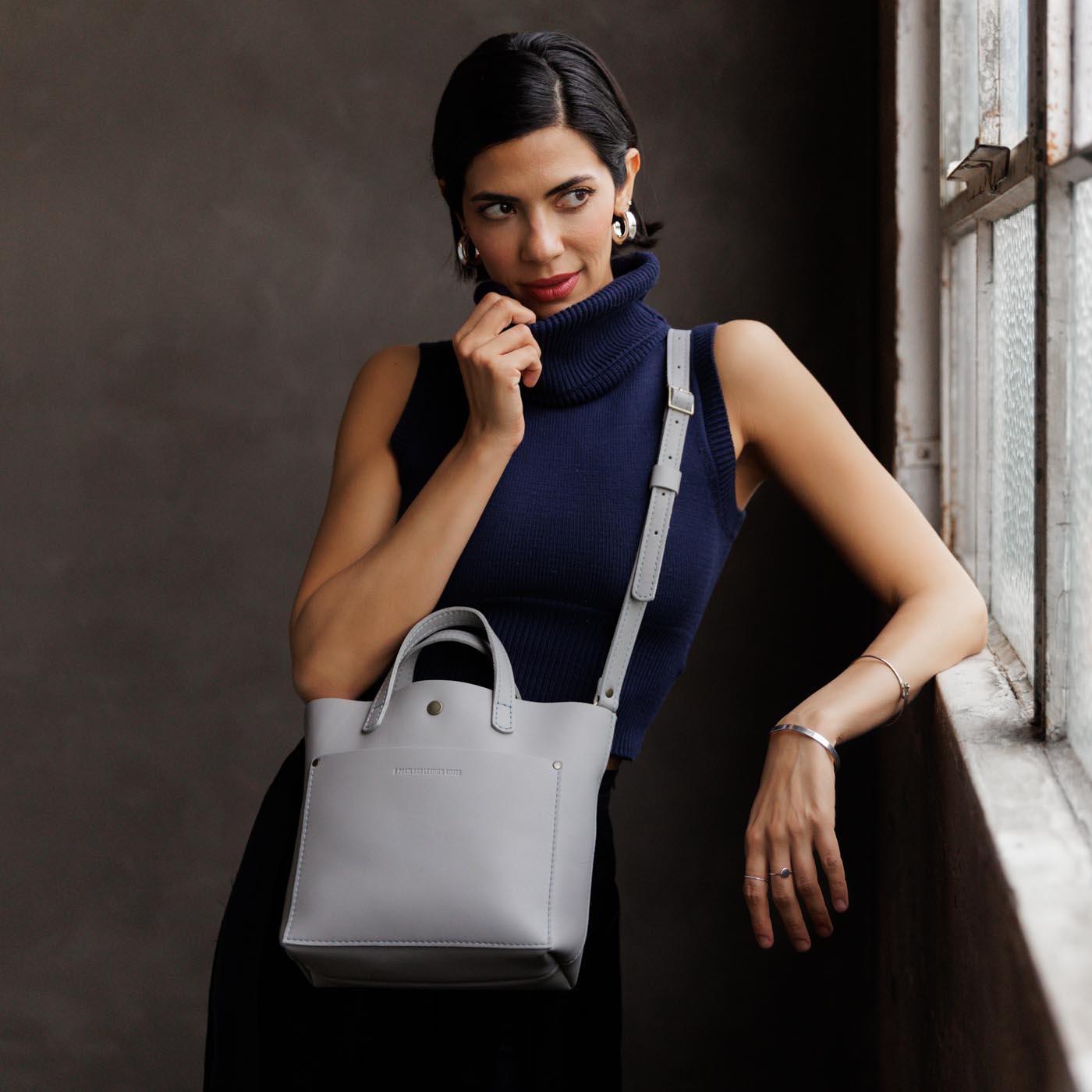 Formal Grey*Classic | Model holding crossbody tote bag with snap closure and front pocket