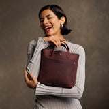 Merlot Classic | Model holding crossbody tote bag with snap closure and front pocket