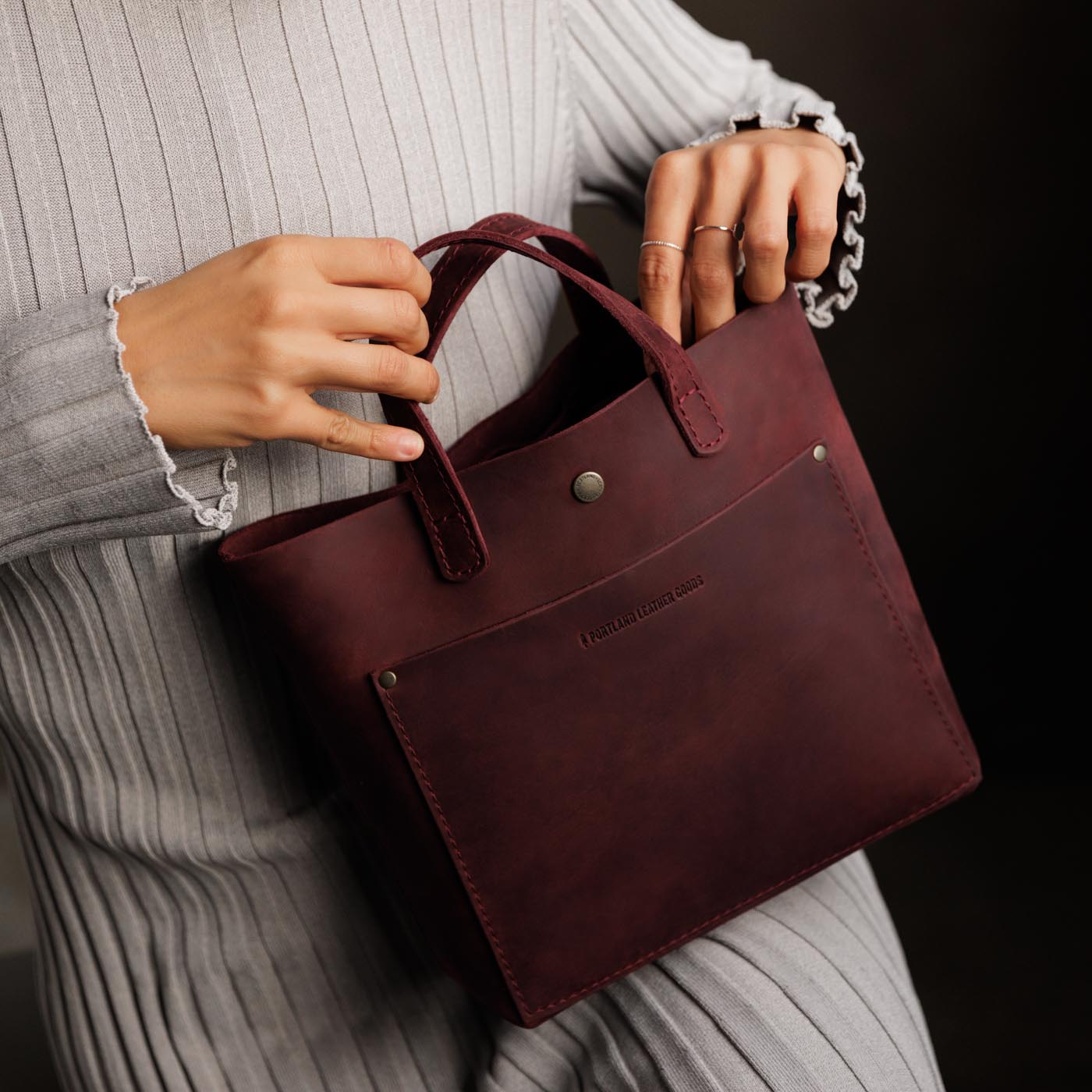 Merlot*Classic | Model holding crossbody tote bag with snap closure and front pocket