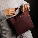 Merlot Classic | Model holding crossbody tote bag with snap closure and front pocket